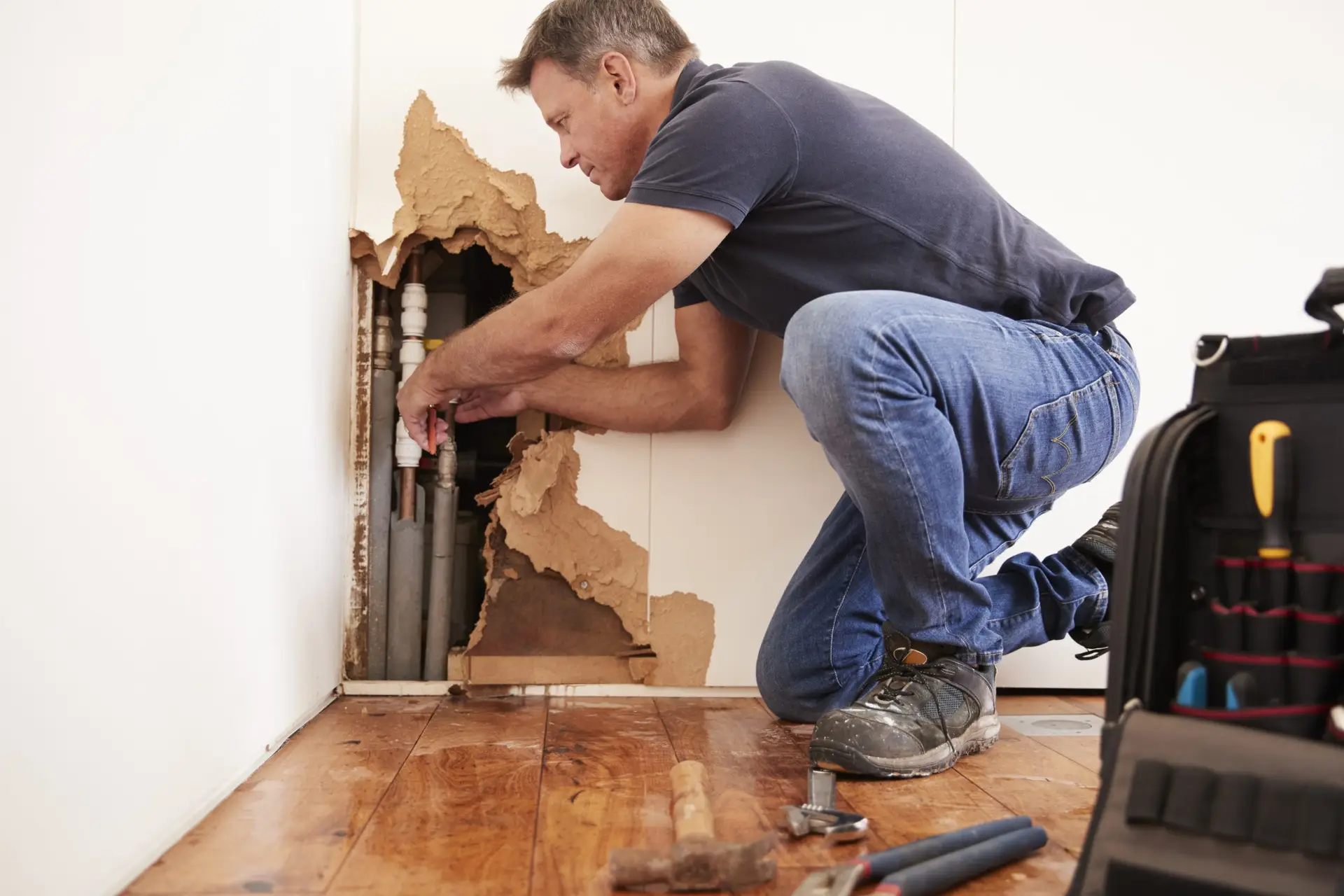 Water Damage Remediation contractor most likely hired by ICAN Services repairing burst water pipe
